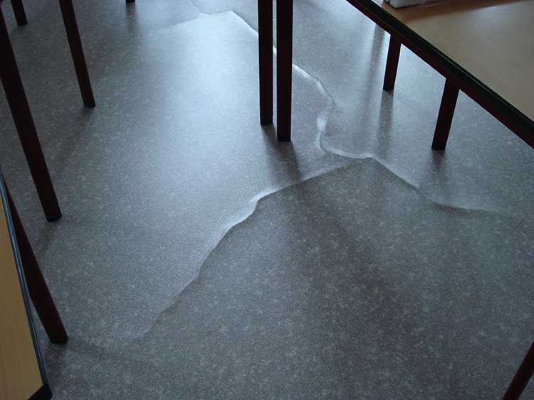Deutlich längliche Blasen im PVC-Belag aufgrund nachstoßender Feuchte aus dem Untergrund
