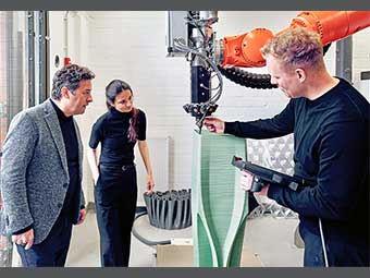 Das Bild zeigt Prof. Ulrich Blum (links), Moritz Wesseler (rechts) und Desislava Paneva (Mitte) am 3-D-Druckroboter des Fachbereichs Architektur der FH Münster. 