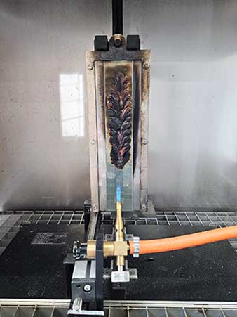 Das Bild zeigt einen modifizierten Einzelflammentest an einer duroplastischen Klebstofffolie.
