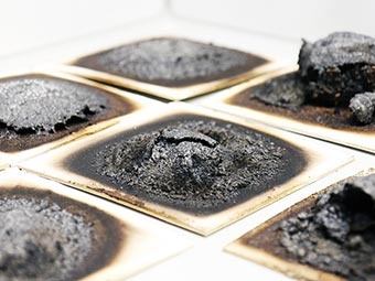 Das Bild zeigt verschiedene intumeszierende Beschichtungen nach der Beflammung im Laborbrandprüfstand des Fraunhofer WKI.  