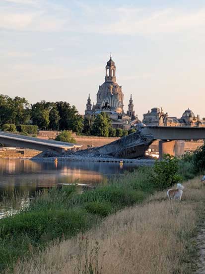 Blick auf die Frauenkirche in Dresden: im Vordergrund die Elbe und die eingestürzte Carolabrücke 