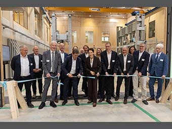 Gruppe von Personen in Geschäftskleidung bei einer Banddurchtrennung in einer modernen Halle, als feierliche Eröffnung einer Einrichtung. 